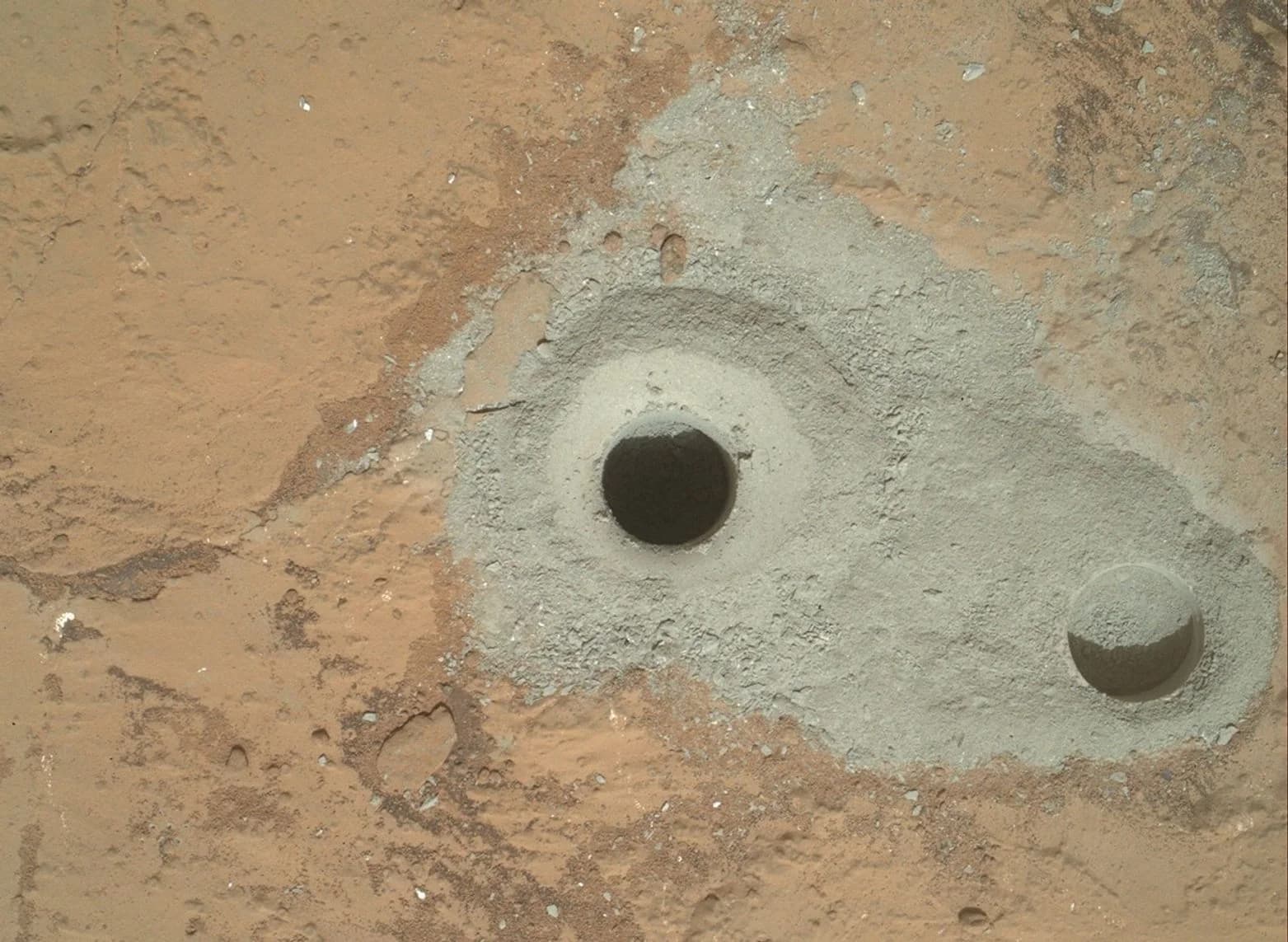 Curiosity rover's first sample drill hole and a shallower test hole in Martian rock