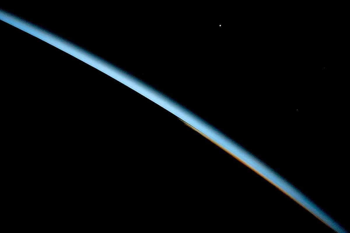 Earth's blue atmospheric limb curving into the darkness of space