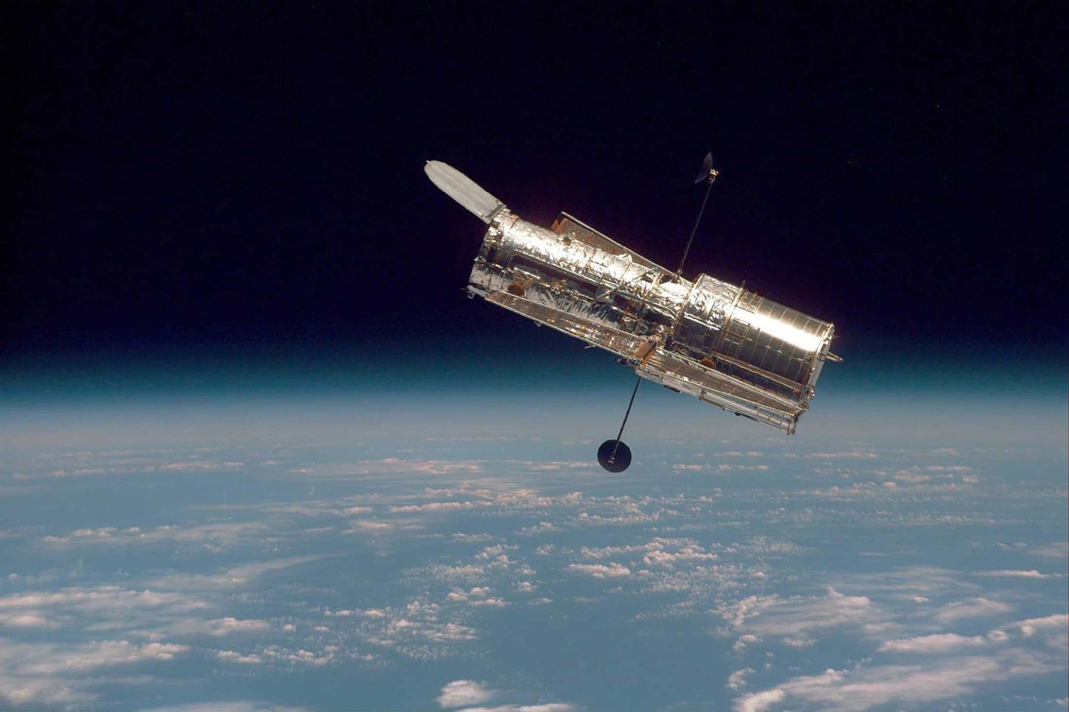 The Hubble Space Telescope floating above Earth's blue horizon in low Earth orbit